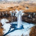 aerial photography of waterfalls near mountains at daytime