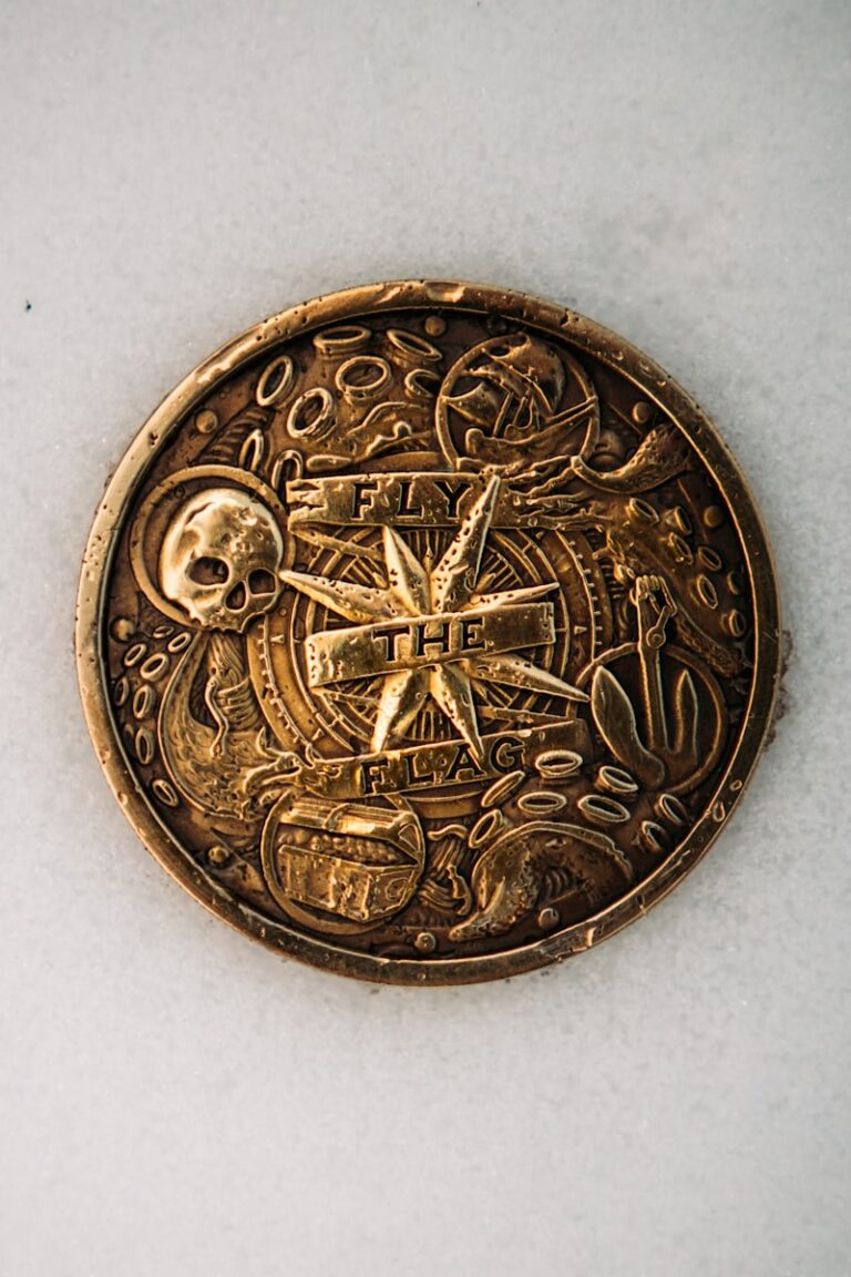 gold round coin on white textile