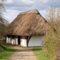 a thatched roof house with a path leading to it