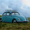 blue Volkswagen Beetle on grass field