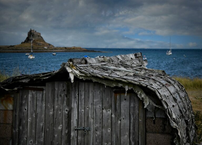 a wooden building with a boat in the water