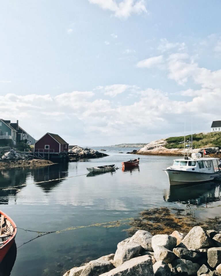 canoe boat on body of water under blue sky