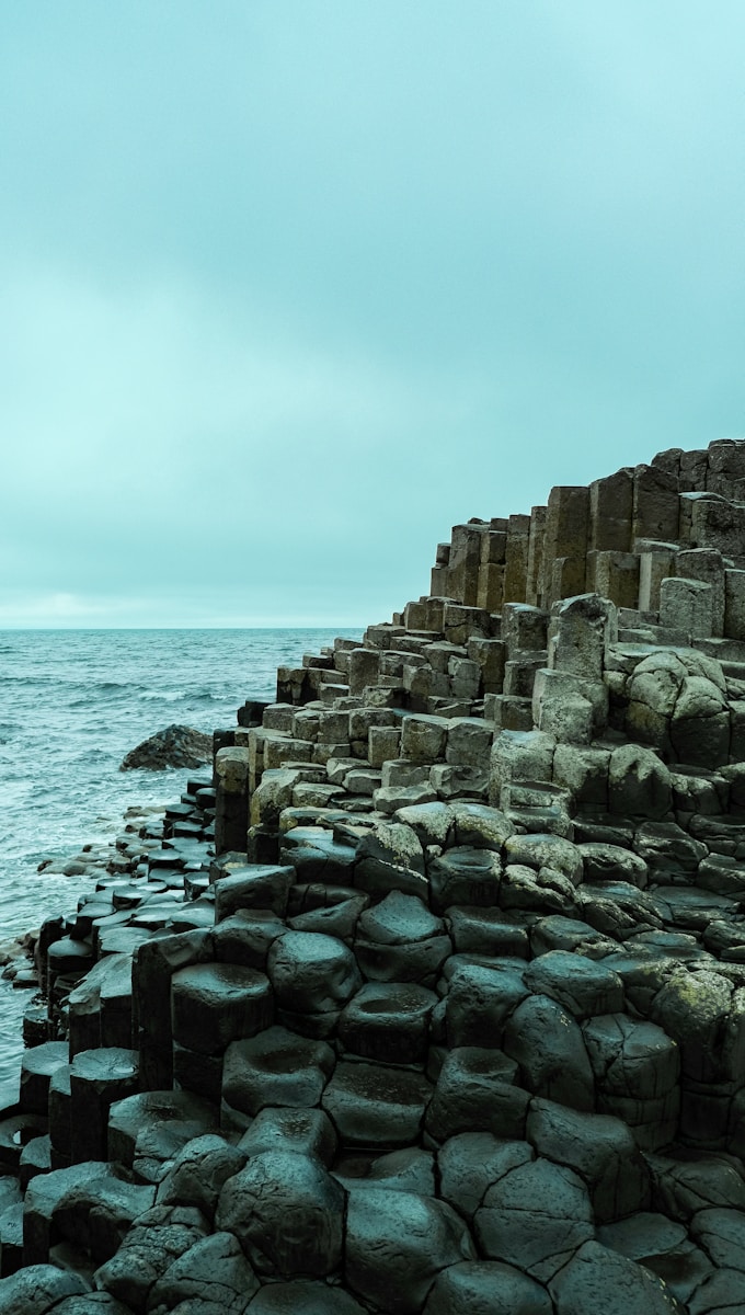 a large body of water next to a rocky shore