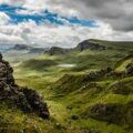 green grass on mountain under white cloudy sky