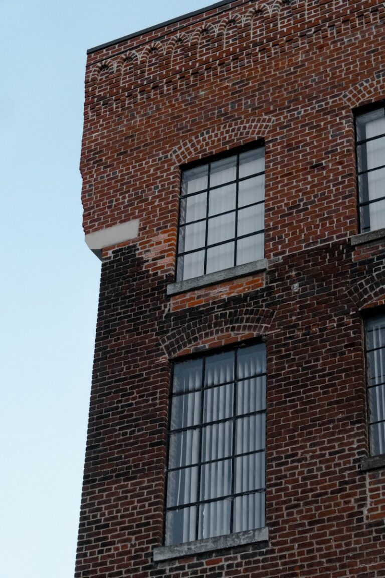 a brick building with three windows and a clock