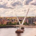 a bridge over a river with a city in the background