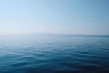 body of water under blue and white sky at daytime