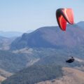 a person is parasailing over a mountain range