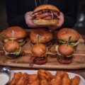burger with lettuce and tomato on brown wooden tray