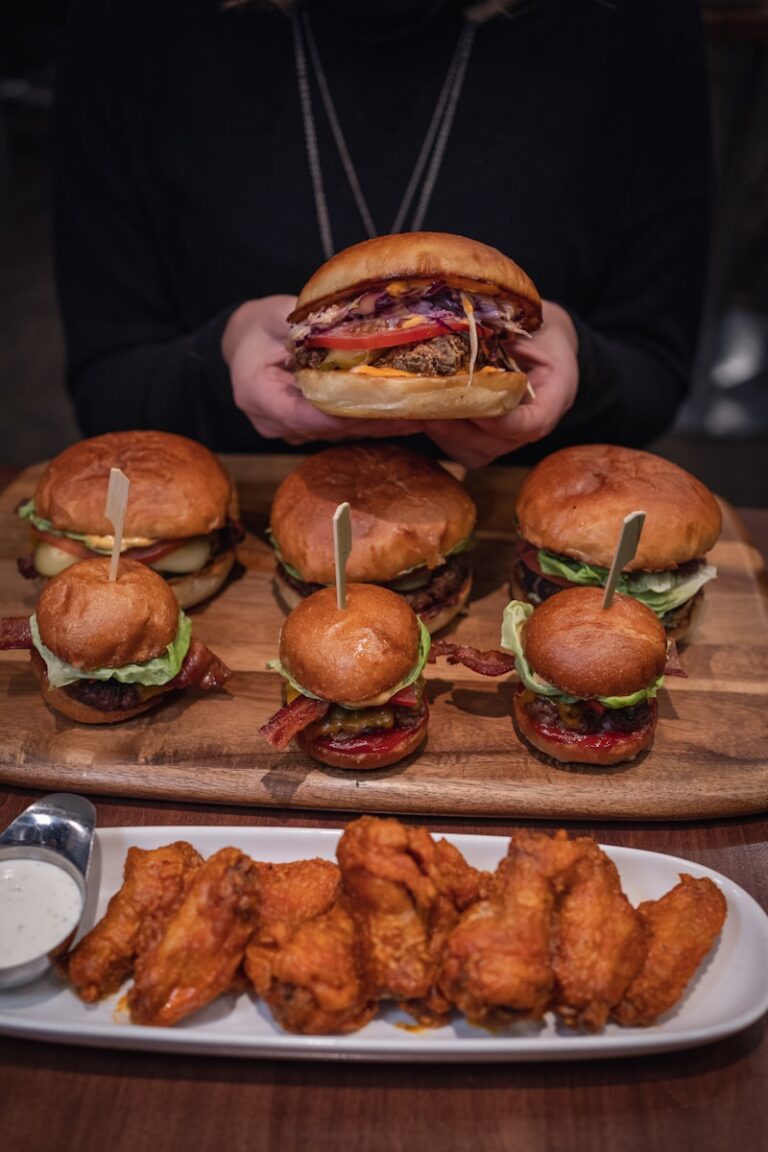 burger with lettuce and tomato on brown wooden tray