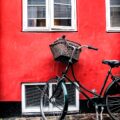 black cruiser bicycle beside red wall