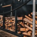 a train is parked next to a pile of logs