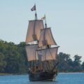 brown galleon ship on body of water near trees